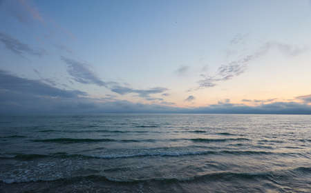 Baltic sea at sunset. Dramatic sky, glowing clouds, soft sunlight, midnight sun. Twilight, summer night. Picturesque dreamlike seascape, cloudscape, nature. Panoramic viewの写真素材