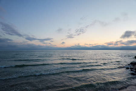Baltic sea at sunset. Dramatic sky, glowing clouds, soft sunlight, midnight sun. Twilight, summer night. Picturesque dreamlike seascape, cloudscape, nature. Panoramic viewの写真素材