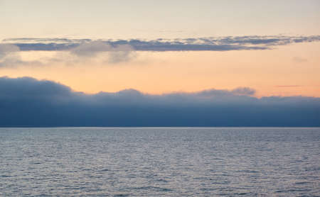 Baltic sea at sunset. Dramatic sky, blue and pink glowing clouds, soft golden sunlight, midnight sun. Picturesque dreamlike seascape, cloudscape, nature. Panoramic viewの写真素材