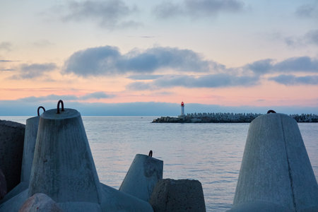 Baltic sea after the storm. Promenade to the lighthouse. Breakwaters. Dramatic sky, clouds, midnight sun. Picturesque dreamlike seascape, cloudscape. Nature, travel destinations. Panoramic viewの写真素材