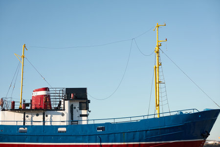 Old red blue museum fishing boat standing on land. Ventspils cargo port terminal, Latvia, Baltic sea. Past, history, industry, traditional craft, travel destinations, sightseeing themesのeditorial素材