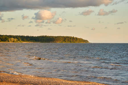 Baltic sea shore. Beach, sand dunes. Dramatic sky, glowing sunset clouds. Picturesque panoramic...