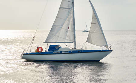 White sloop rigged yacht sailing in the Baltic sea on a clear day. Transportation, cruise, yachting, regatta, sport, recreation themes. Travel, exploring, wanderlust conceptsの写真素材