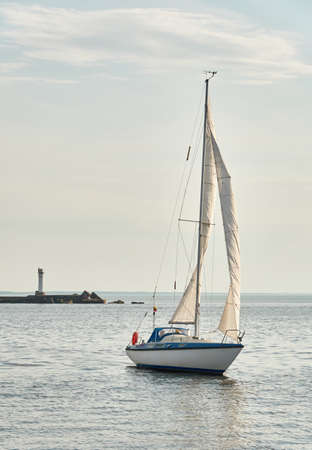 White sloop rigged yacht sailing in the Baltic sea on a clear day. Transportation, cruise, yachting, regatta, sport, recreation themes. Travel, exploring, wanderlust conceptsの写真素材