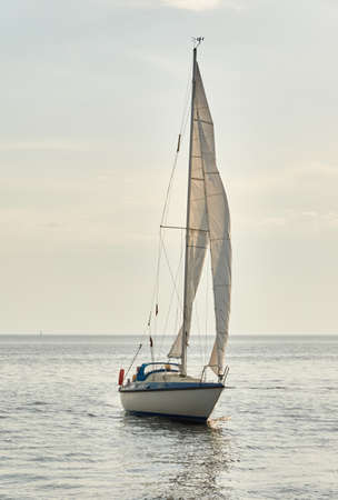 White sloop rigged yacht sailing in the Baltic sea on a clear day. Transportation, cruise, yachting,...