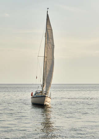 White sloop rigged yacht sailing in the Baltic sea on a clear day. Transportation, cruise, yachting, regatta, sport, recreation themes. Travel, exploring, wanderlust conceptsの写真素材