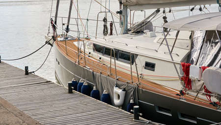 Modern aluminum exploration sailboat moored to a pier in a yacht marina. High latitudes, autonomous boats, extreme sailing concepts. Transportation, sport, recreation, adventures, exploringの写真素材