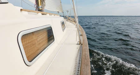 White sloop rigged yacht sailing in the Baltic sea after the storm. Waves, splashes, water surface....
