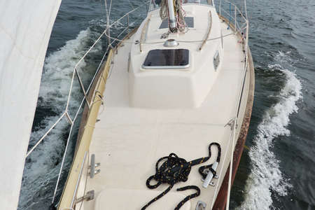 White sloop rigged yacht sailing in the Baltic sea after the storm. Waves, splashes, water surface. Cruise, summer vacations, regatta, sport, leisure activity, tourism, wanderlust conceptsの写真素材