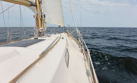 White sloop rigged yacht sailing in the Baltic sea after the storm. Waves, splashes, water surface....