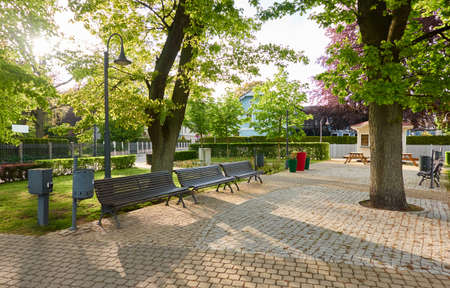 Closed cafe (food kiosk) in a city park. An empty street covered with cobblestone, alley, benches. Spring, early summer. Latvia, Europe. Tourism, public places, vacations, small business conceptsの写真素材
