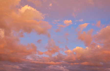 Clear blue sky. glowing pink and golden cirrus and cumulus clouds after storm, soft sunlight.の写真素材