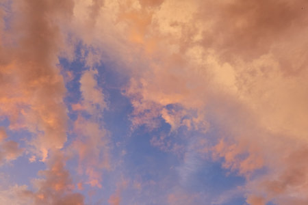 Clear blue sky. glowing pink and golden cirrus and cumulus clouds after storm, soft sunlight.の写真素材