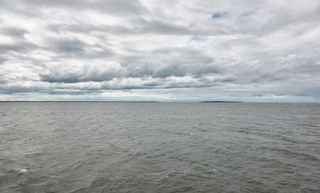 Muhu strait, Estonia, Baltic sea. Dramatic sky, storm clouds, water surface texture. Panoramic view. Nature, eco tourism, weather themes;の写真素材