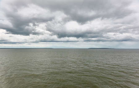 Muhu strait, Estonia, Baltic sea. Dramatic sky, storm clouds, water surface texture. Panoramic view. Nature, eco tourism, weather themes;の写真素材