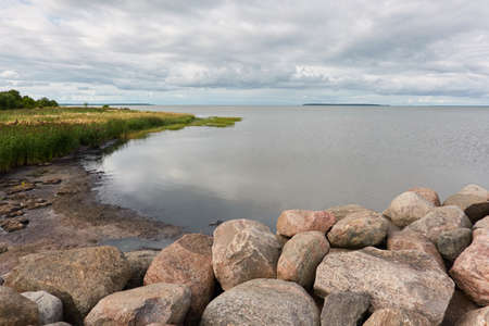 Panoramic view from the rocky sea shore. Dramatic sky. clouds. Kuivastu harbour, Estonia. Nature, eco tourism, wanderlust, summer vacation conceptsの写真素材