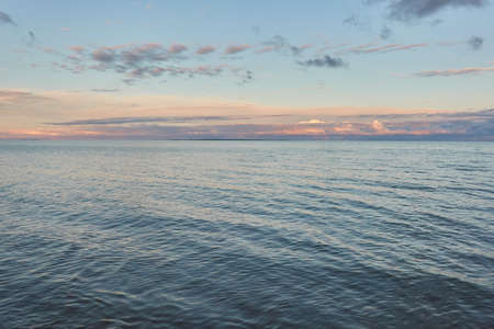 Baltic sea shore (beach) at sunset, panoramic view. Soft sunlight, midnight sun, clear sky, glowing clouds. Saaremaa island, Estonia. Atmospheric summer landscapeの写真素材