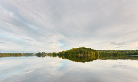 Majestic evergreen forest and Suiro lake (Kulovesi). Finland. Scandinavia, Europe. Reflections in a still water, clear sky. Autumn landscape. Nature, seasons, ecotourism, peace and harmony conceptsの写真素材