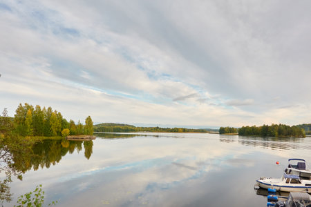 Motor boats, cutters and small fishing boats moored to a pier in a camping site. Forest in the background. Suiro lake (Kulovesi), Finland. Nature, vacations, recreation, ecotourism conceptsの写真素材
