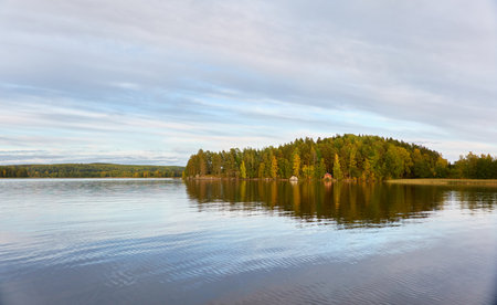 Majestic evergreen forest and Suiro lake (Kulovesi). Finland. Scandinavia, Europe. Reflections in a still water, clear sky. Autumn landscape. Nature, seasons, ecotourism, peace and harmony conceptsの写真素材