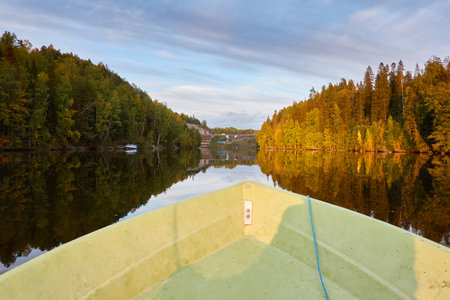 Forest lake at sunset. View from the boat. Suiro lake (Kulovesi), Finland. Soft sunlight, golden hour. Early autumn. Nature, eco tourism, vacations, fishing and boatingの写真素材