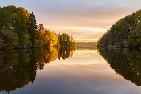 Majestic evergreen forest and lake at sunset. Soft golden sunlight, clear sky, glowing clouds.. Autumn. Suiro lake (Kulovesi), Finland. Panoramic view. Pure nature, ecotourism conceptsの写真素材
