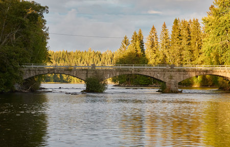 Stone road bridge over the canal, river or lake. Forest park. Finland. Early autumn. Urban landscape. Nature, travel destinations, landmarks conceptsの写真素材