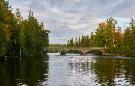 Stone road bridge over the canal, river or lake. Forest park. Finland. Early autumn. Urban landscape. Nature, travel destinations, landmarks conceptsの写真素材