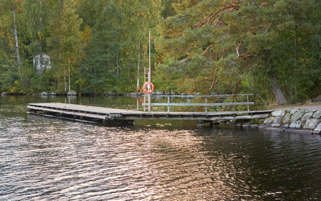 River (canal) in a forest park. Promenade, pier and walking area. Early autumn landscape. Finland. Nature, environment, eco tourism themesの写真素材