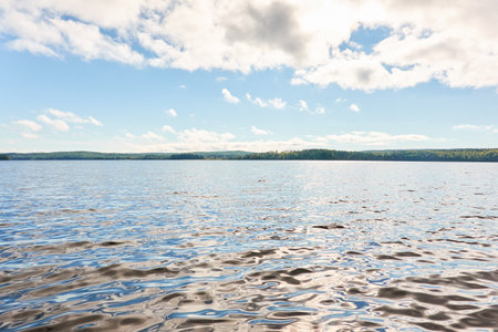 Forest lake on a sunny day. Finland. Scandinavia, Europe. Clear sky, glowing clouds. Autumn landscape. Nature, seasons, ecotourism, peace and harmony conceptsの写真素材