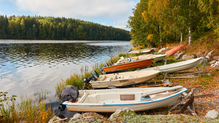 Motor boats, cutters and small fishing rowing boats moored to a pier in a camping site. Forest in the background. Finland. Nature, vacations, recreation, ecotourism, lifestyle conceptsの写真素材