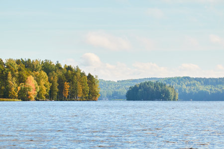 Forest lake on a sunny day. Finland. Scandinavia, Europe. Clear sky, glowing clouds. Autumn landscape. Nature, seasons, ecotourism, peace and harmony conceptsの写真素材