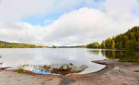 Forest lake on a sunny day. Finland. Scandinavia, Europe. Clear sky, glowing clouds. Autumn landscape. Nature, seasons, ecotourism, peace and harmony conceptsの写真素材