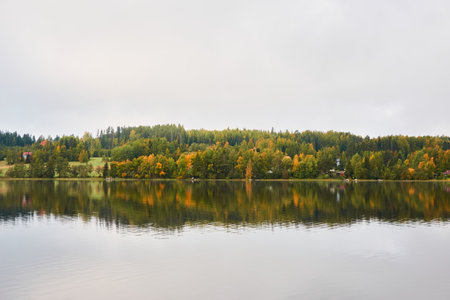 Forest lake (river) on a cloudy day. Reflections in water. Glowing clouds after the rain. Finland. Idyllic autumn landscape. Pure nature, ecology, ecological reserve, ecotourismの写真素材