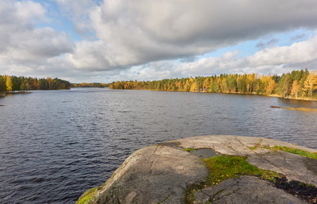 Panoramic view of the rocky forest lake shore on a sunny day. Autumn landscape. Finland, Finnish nature. Ecology, fresh air, ecotourism themesの写真素材