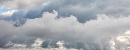 Ornamental clouds. Dramatic sky. Epic storm cloudscape. Soft sunlight. Panoramic image, texture, background, graphic resources, design, copy space. Meteorology, heaven, hope, peace conceptの写真素材