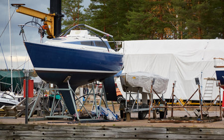 Sailboats standing on land in a yacht marina prepared for winterization or new sailing season. Transportation, repair and service conceptsの写真素材