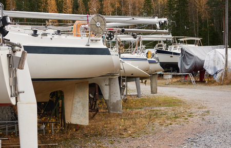 Sailboats standing on land in a yacht marina prepared for winterization or new sailing season. Transportation, repair and service conceptsの写真素材