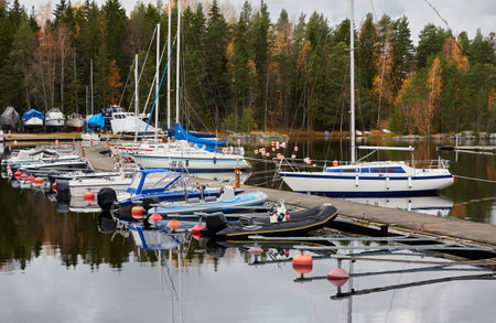 Sailboats moored to a pier and standing on land in a yacht marina prepared for winterization or new sailing season. Transportation, repair and service conceptsの写真素材