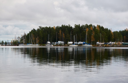 Sailboats moored to a pier and standing on land in a yacht marina prepared for winterization or new sailing season. Transportation, repair and service conceptsの写真素材