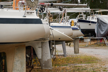 Sailboats standing on land in a yacht marina prepared for winterization or new sailing season. Transportation, repair and service conceptsの写真素材