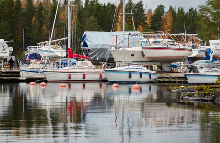 Sailboats moored to a pier and standing on land in a yacht marina prepared for winterization or new...