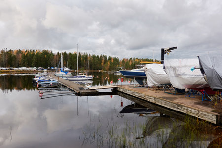 Sailboats moored to a pier and standing on land in a yacht marina prepared for winterization or new sailing season. Transportation, repair and service conceptsの写真素材