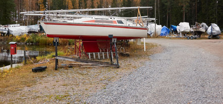 Sailboats standing on land in a yacht marina prepared for winterization or new sailing season. Transportation, repair and service conceptsの写真素材