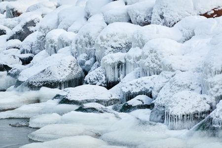 Frozen sea, stones, icicles. Cloudy day, Ice, snow. Fickle weather, blizzard. Winter, global...