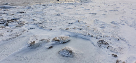 Cracked ice and water surface, frozen sea shore, texture, close-up. picturesque winter scenery....