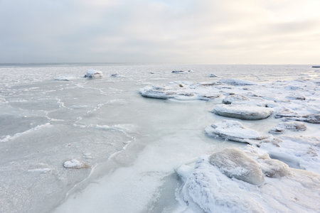 Snow-covered Baltic sea shore at sunrise.Snow, ice, frozen water. soft sunlight. picturesque winter...