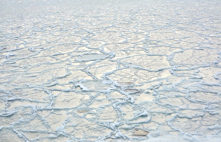 Frozen water surface, cracked ice and icy sea foam texture. cold weather. Winter landscape or background, graphic resources. Nature, seasons, environment, ecology, climate change conceptsの写真素材