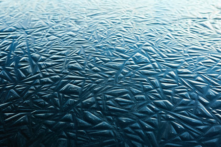 Cracked ice, dark water surface, frozen lake shore. Geometric natural pattern. Winter landscape, picturesque scenery. Concept image, graphic resources. Nature, ecology, climate, global warmingの写真素材