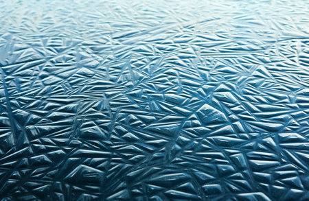 Cracked ice, dark water surface, frozen lake shore. Geometric natural pattern. Winter landscape, picturesque scenery. Concept image, graphic resources. Nature, ecology, climate, global warmingの写真素材